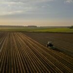 Tracteur labourant un champ au coucher du soleil à l'automne : la Saint-Michel marque la fin de nombreux baux ruraux