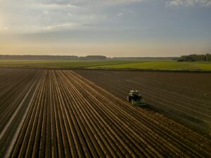 Tracteur labourant un champ au coucher du soleil à l'automne : la Saint-Michel marque la fin de nombreux baux ruraux