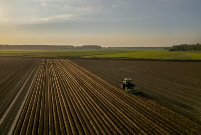 Tracteur labourant un champ au coucher du soleil à l'automne : la Saint-Michel marque la fin de nombreux baux ruraux